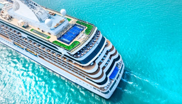 A top down view of a cruise ship in crystal blue water.