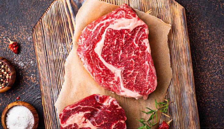 A fresh steak laid out on a cutting board, ready to be seasoned.