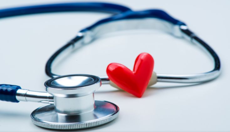 A stethescope and red heart on a white background.