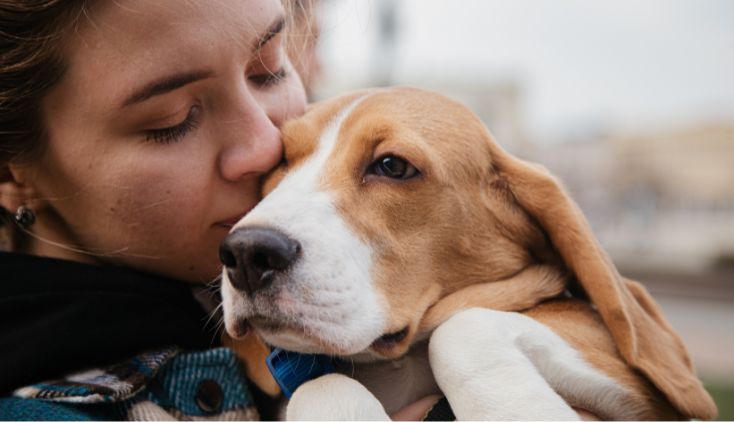 A woman hugging her basset hound.